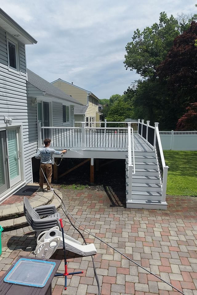 Washing a raised backyard deck and its stairs from the paver patio below