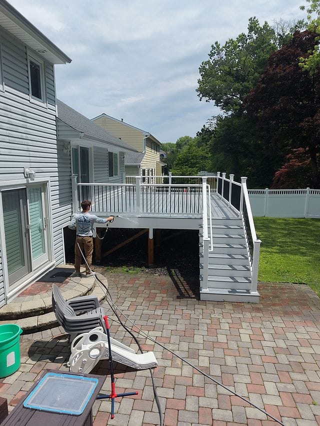 Washing a raised backyard deck and its stairs from the patio below
