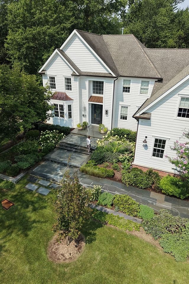 Drone view of a white colonial home cleaned front to back